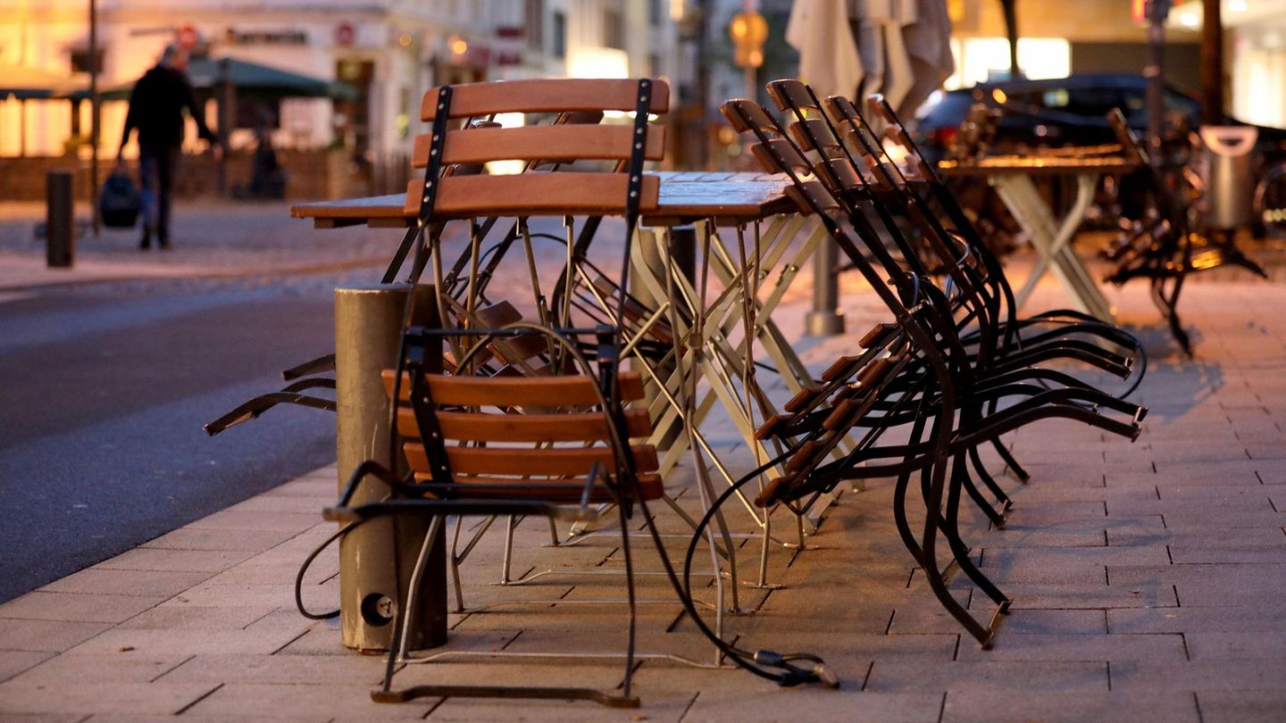 Stühle und Tische sind am Morgen vor einer Gaststätte in Köln zusammengestellt